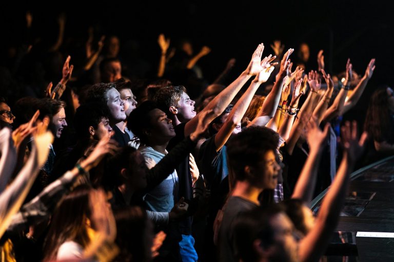 Fans with hands raised at a concert